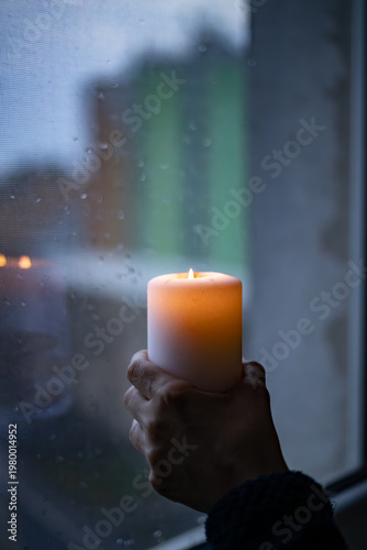 Holding Hope: Candle in Hand During Power Outage in Ukraine	