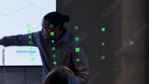 Standing lead presenter starting by pointing at charts in business green squares showing trends