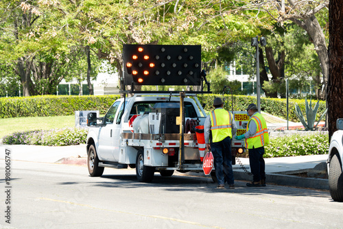 Obraz na plátně Road crew workers directing traffic with a truck and arrow board