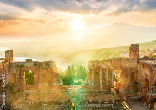 beautiful sunset landscape in old italian town with ancient buildings, green mountains and scenic evening sky in golden sunset rays