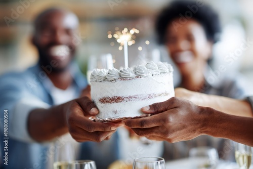 African American couple celebrating birthday with cake and sparkler at home