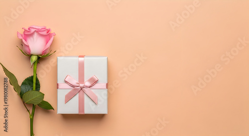 Pink rose and gift box with ribbon on soft pastel background for Mother's Day celebration
