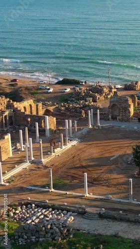 Aerial view of the ancient city ruins of Side on Türkiye’s Antalya coast, showcasing Roman architecture remains and coastal layout under sunset light.