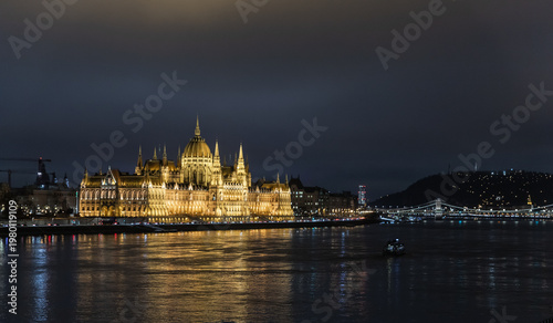 View from Margit Margaret Bridge of Parliament building illuminated by floodlights on Pest embankment in Budapest in Hungary
