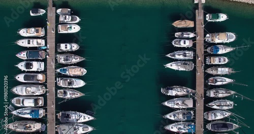 Symmetrical Marina With Carefully Placed Vessels. Overhead View Illustrating Orderly Pier Arrangement With Moored Yachts And Tranquil Green Ocean Surroundings