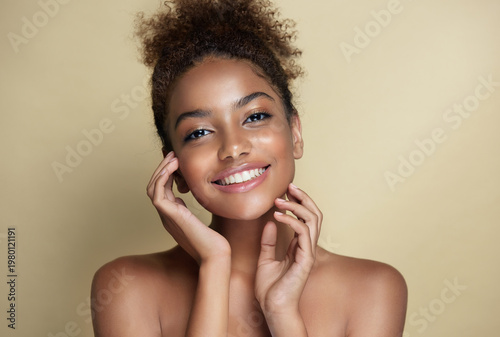 Beauty portrait of african american woman with clean healthy skin on beige background. Smiling dreamy beautiful afro hairstyle  girl.Curly afro  black hair
