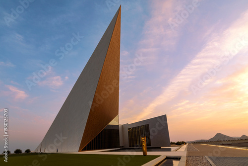 Obraz na płótnie Oman Across Ages Museum with striking modern architecture captured at sunset highlighting geometric design and dramatic sky