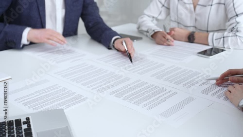 Business people discussing contract terms, outlining agreements, and reviewing legal documents during a corporate meeting, preparing for a significant partnership signing and negotiation