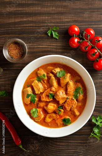  Indian dish chicken tikka masala in bowl on wooden background