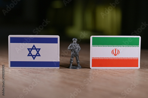 A tin soldier on the background of the flags of Iran and Israel.