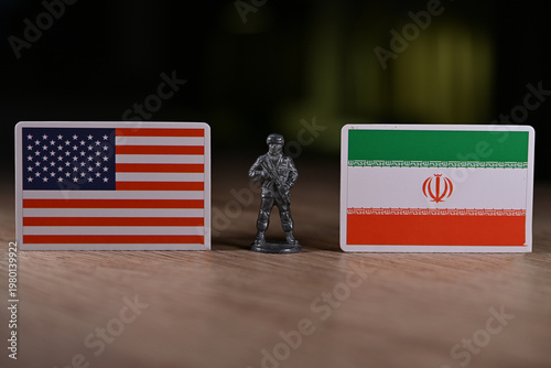 A tin soldier on the background of the flags of the United States and Iran.