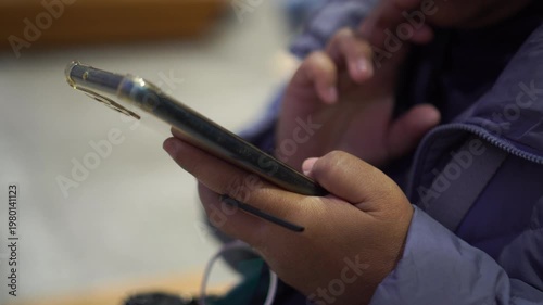 Using mobile smartphone check flight schedule wait in airport terminal