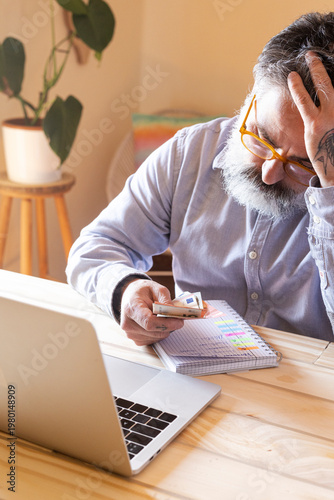 Mature man struggling with personal finance, managing debt, and budget