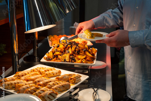 Wallpaper Mural Person serving hot dishes at a hotel buffet with tongs Torontodigital.ca