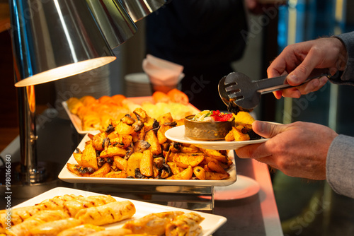 Wallpaper Mural Person serving roasted potatoes from a buffet station Torontodigital.ca