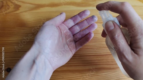 Close-up video of antiseptic liquid being sprayed onto a human hand from a spray bottle. Hygiene, sanitation and personal protection concept. Disinfection routine for healthcare, everyday safety