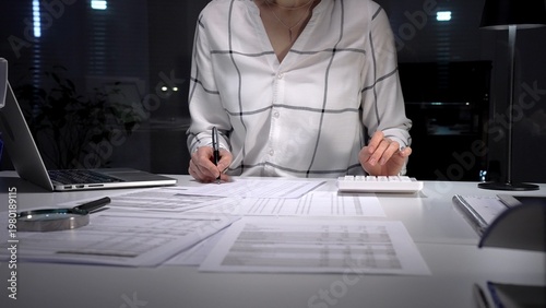 Fotografi Financial specialist working late crunching numbers and analyzing data, completi