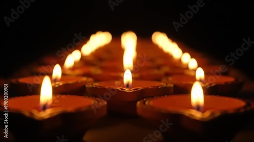 Row of lit diyas creating a warm and inviting ambiance.