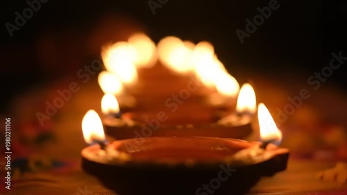 Row of lit diyas creating a warm and inviting ambiance.