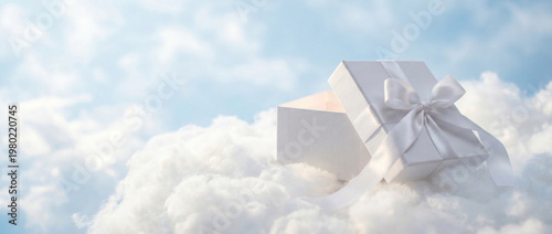 Open white gift box with satin ribbon resting on soft clouds against a pale blue sky, creating an elegant celebratory concept for surprise, luxury packaging, romance or heavenly themes