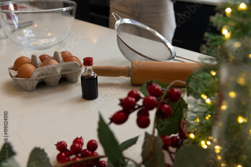 Blurred person wearing apron preparing baking tools on marble countertop with rolling pin, eggs