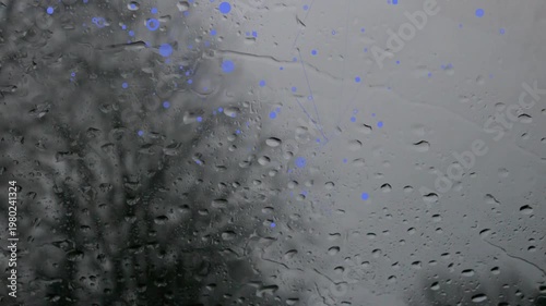 Steady rain forming and merging on windshield, creating blue reflections for automotive design
