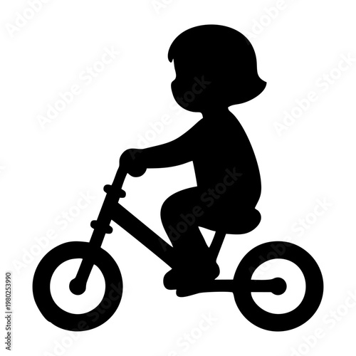 silhouette of a small child riding a balance bike