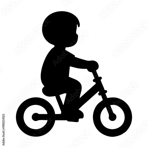 silhouette of a small child riding a balance bike