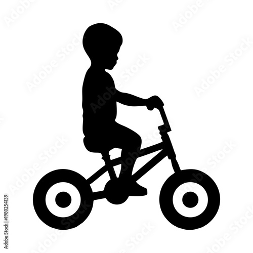 silhouette of a small child riding a balance bike