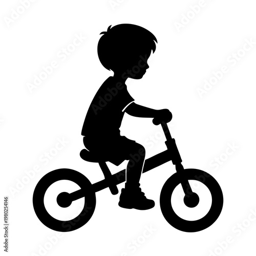 silhouette of a small child riding a balance bike