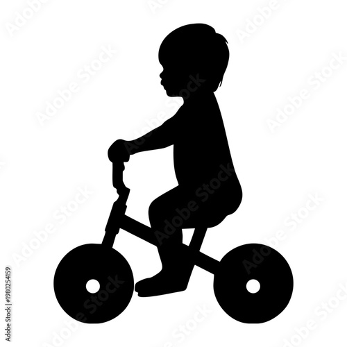 silhouette of a small child riding a balance bike