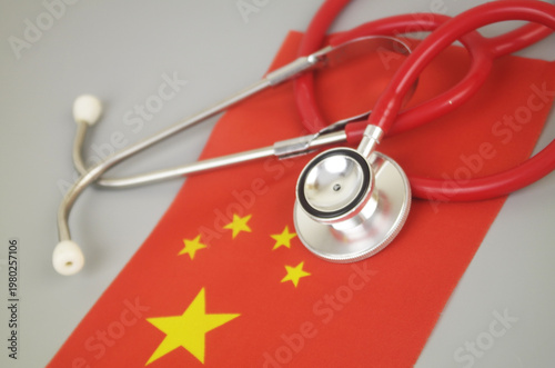Red stethoscope on flag of China. Chinese medicine and health insurance concept.