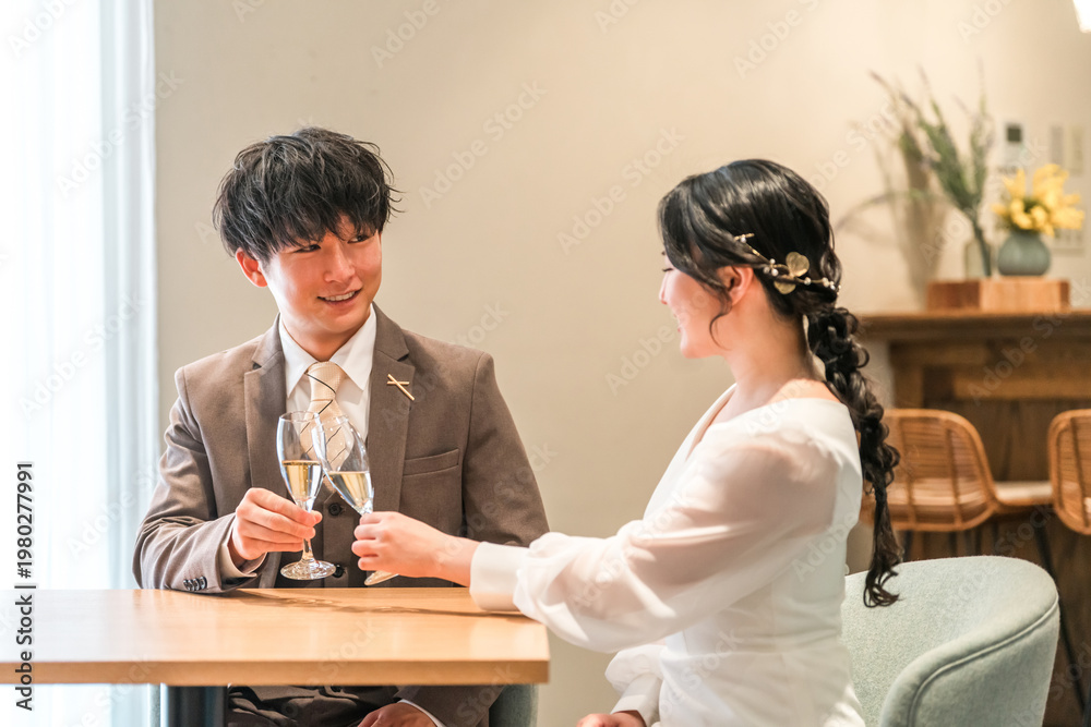 Obraz premium A couple dressed in formal attire chatting while drinking champagne at a restaurant or bar.