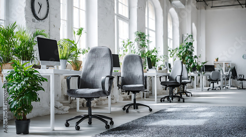 A large open office space with many chairs and potted plants