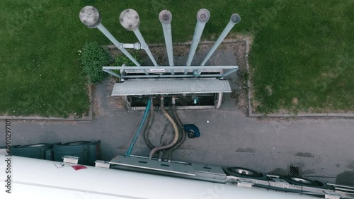High angle view of a worker refilling fuel from a tank truck at a gas station