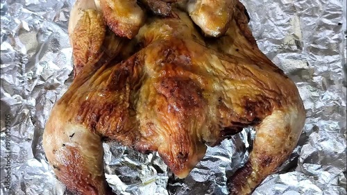 Grilled whole chicken on foil paper, indoor Chiangmai Thailand.