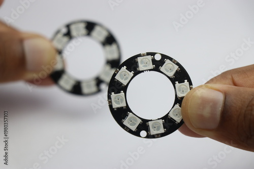 RGB Led ring light with 8 leds held in the hand on white background. Pixel ring light for electronics project
