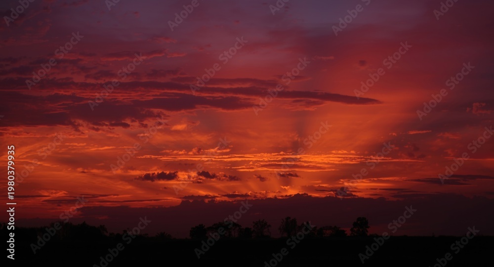 Obraz premium Striking evening horizon with radiant ruby toned clouds