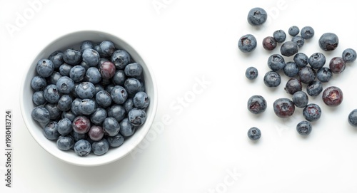 White bowl of ripe blueberries on a clean white surface with copy space