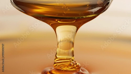 Golden honey pouring from silver spoon in slow motion captured for this beautiful high quality professional food stock video footage
