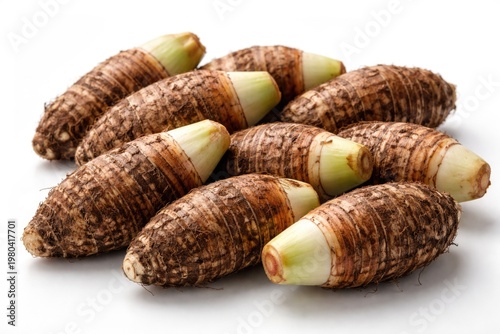 white background with fresh taro roots arranged neatly