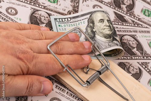 Canvastavla A hand in a mousetrap and a $100 bill against a background of $1 bills