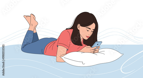 Relaxed young woman lies on her stomach on a pillow and looks at her mobile smartphone screen while resting on a blue surface.