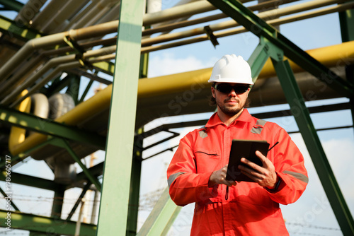 Fotografia Technician inspecting heavy machinery infrastructure at plant