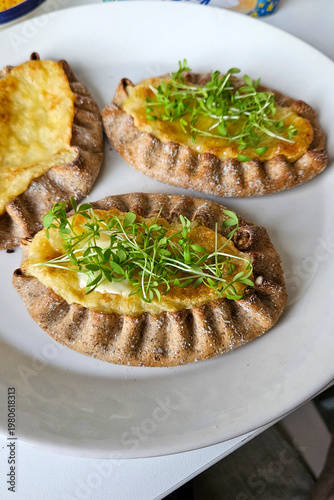 Vegan Karelian pies with plant-based topping and microgreens