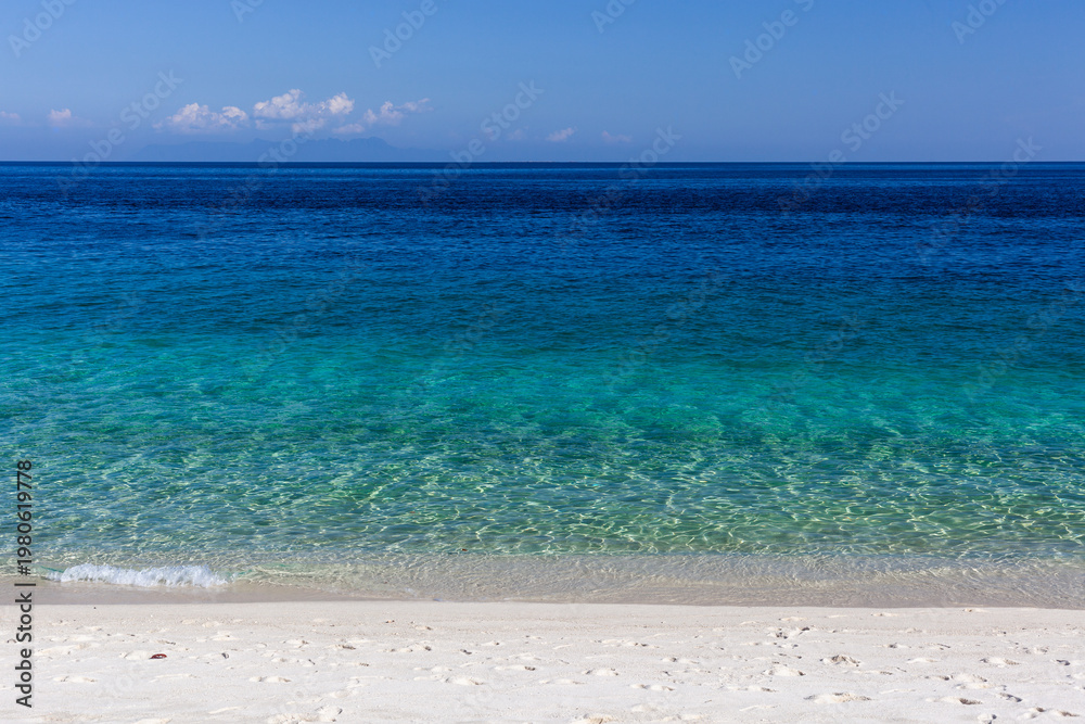 Fototapeta premium Tropical beach at Koh Adang, Thailand. Clear turquoise water meets sandy shoreline. Part of Tarutao National Park, serene coastal scene.