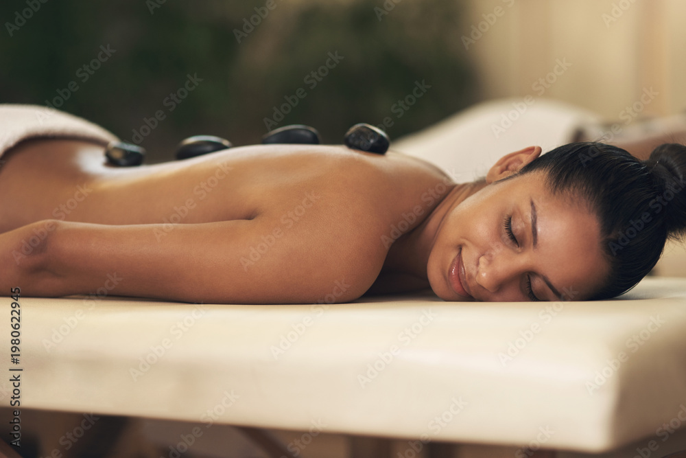 Obraz premium Spa, relax or woman with hot stone massage, therapeutic body care or holistic treatment for health. Stress relief, relaxation therapy or client with warm rocks for muscle tension, healing or smile