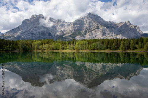 Majestic Mountain Range Reflected in Calm Alpine Lake With Fores