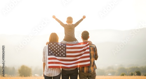 Family holding american flag with child on father's shoulders