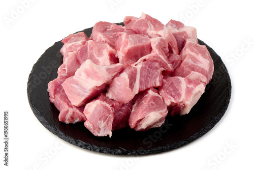 Fresh diced pork on black slate, isolated on white background